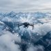 Drone autonome survolant des nuages montagneux froids, avec une visualisation délicate de particules d’iodure d’argent et de cristaux de glace dans une atmosphère alpine bleutée.